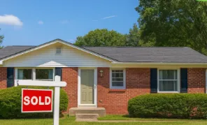 A residential home with a sold sign in the front yard